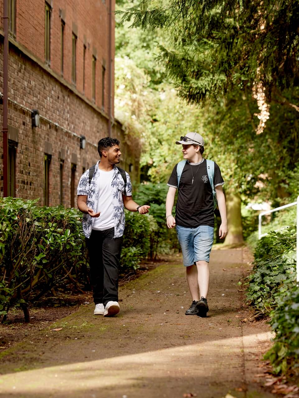 Two students walking by accommodation on Keele campus.